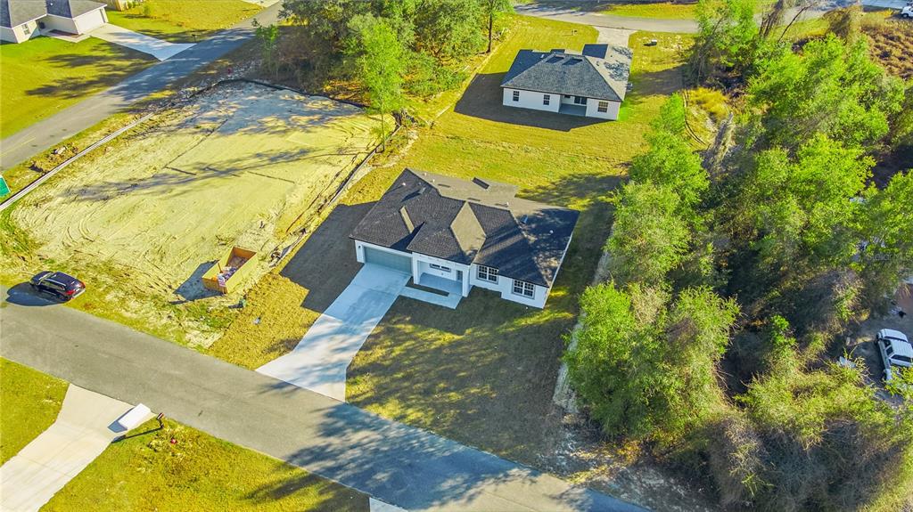 An aerial view shows two newly constructed houses on large lots with surrounding trees — 13690 SW 43RD CIRCLE, OCALA, FL