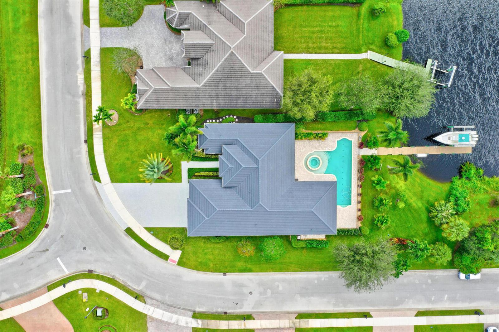 An aerial view shows a house with a pool and dock next to a lake — 7186 SW Quiet River Court, Stuart FL 34997, STUART, FL
