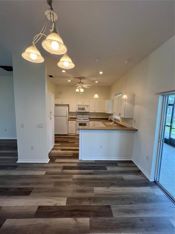 A kitchen with white cabinets, stainless steel appliances, and wood-look flooring — 4733 S CRANBERRY BOULEVARD, NORTH PORT, FL