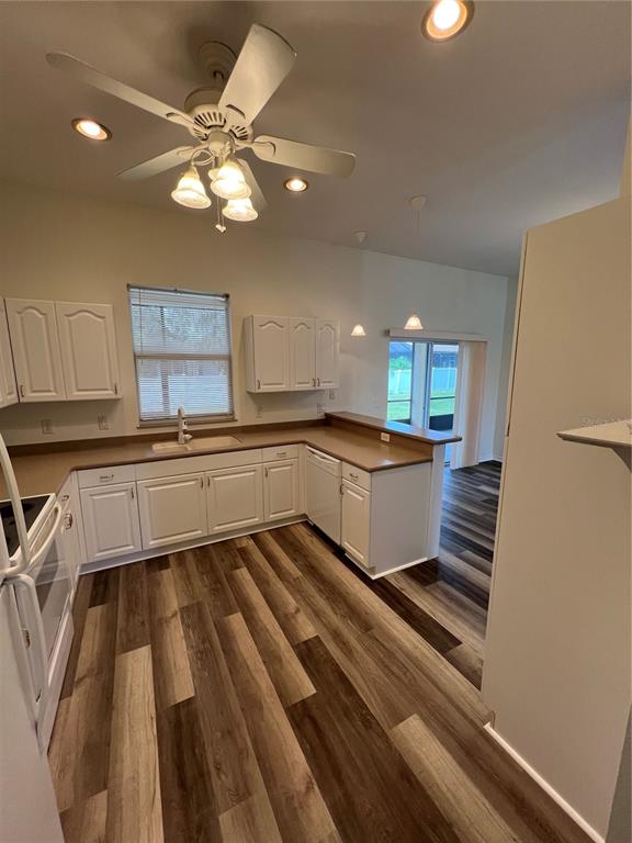 A kitchen with white cabinets, brown countertops, and wood-look flooring — 4733 S CRANBERRY BOULEVARD, NORTH PORT, FL