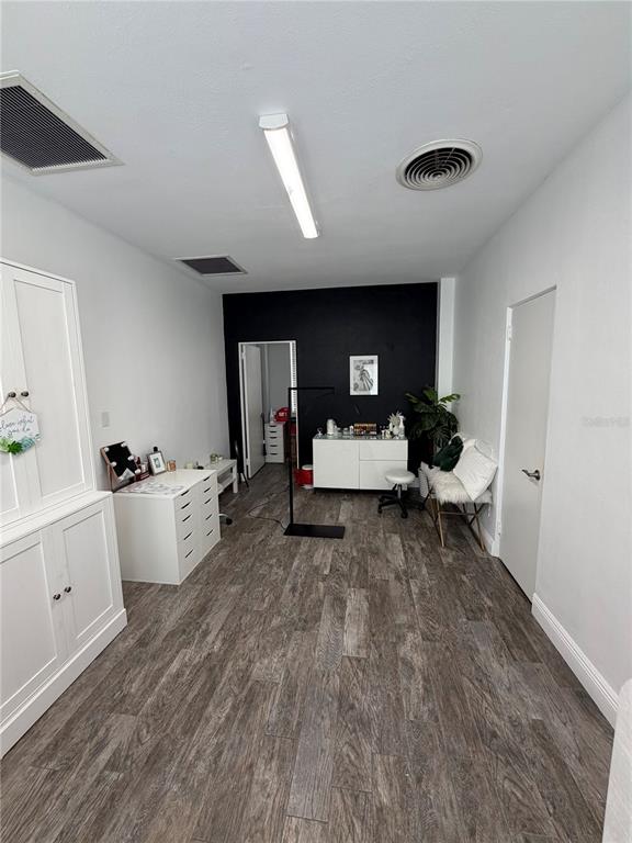 A room with wood-look flooring, a black accent wall, and white storage furniture — 320 N MAGNOLIA AVENUE UNIT Suite B4, ORLANDO, FL