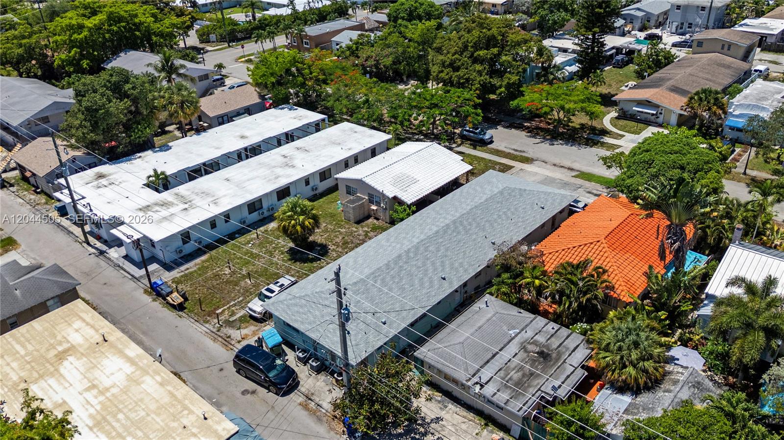 An aerial view shows several residential buildings with various roof styles and surrounding trees — 1938 Pierce St, Hollywood FL 33020, HOLLYWOOD, FL