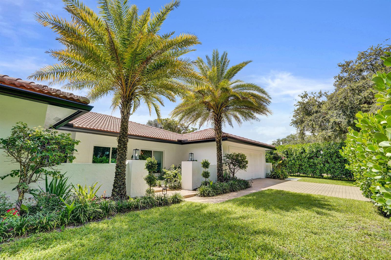 A white single-story house with a tiled roof, palm trees, and a paved driveway — 2804 Banyan Boulevard Circle NW, Boca Raton FL 33431, BOCA RATON, FL