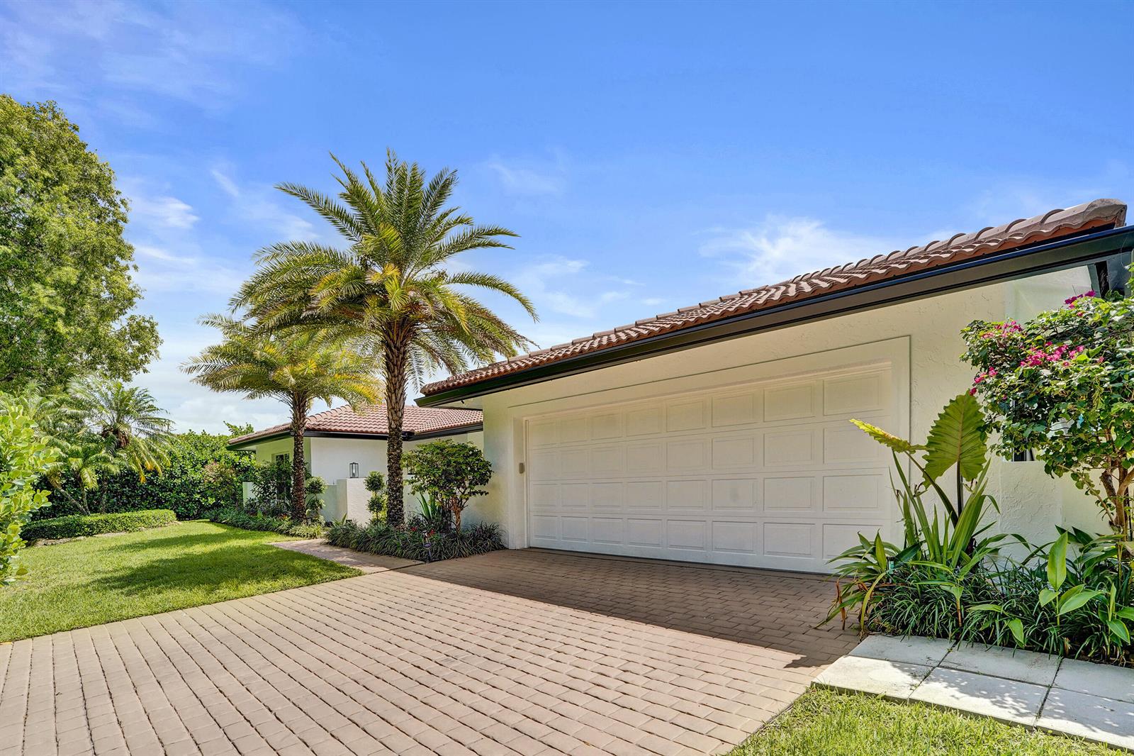A white house with a tiled roof, a two-car garage, and palm trees in the yard — 2804 Banyan Boulevard Circle NW, Boca Raton FL 33431, BOCA RATON, FL