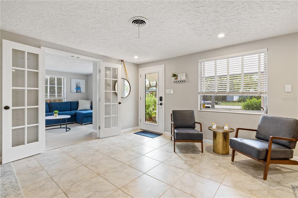 A tiled entryway features two armchairs, a small table, and French doors leading to a living room — 2365 BAY STREET, SARASOTA, FL