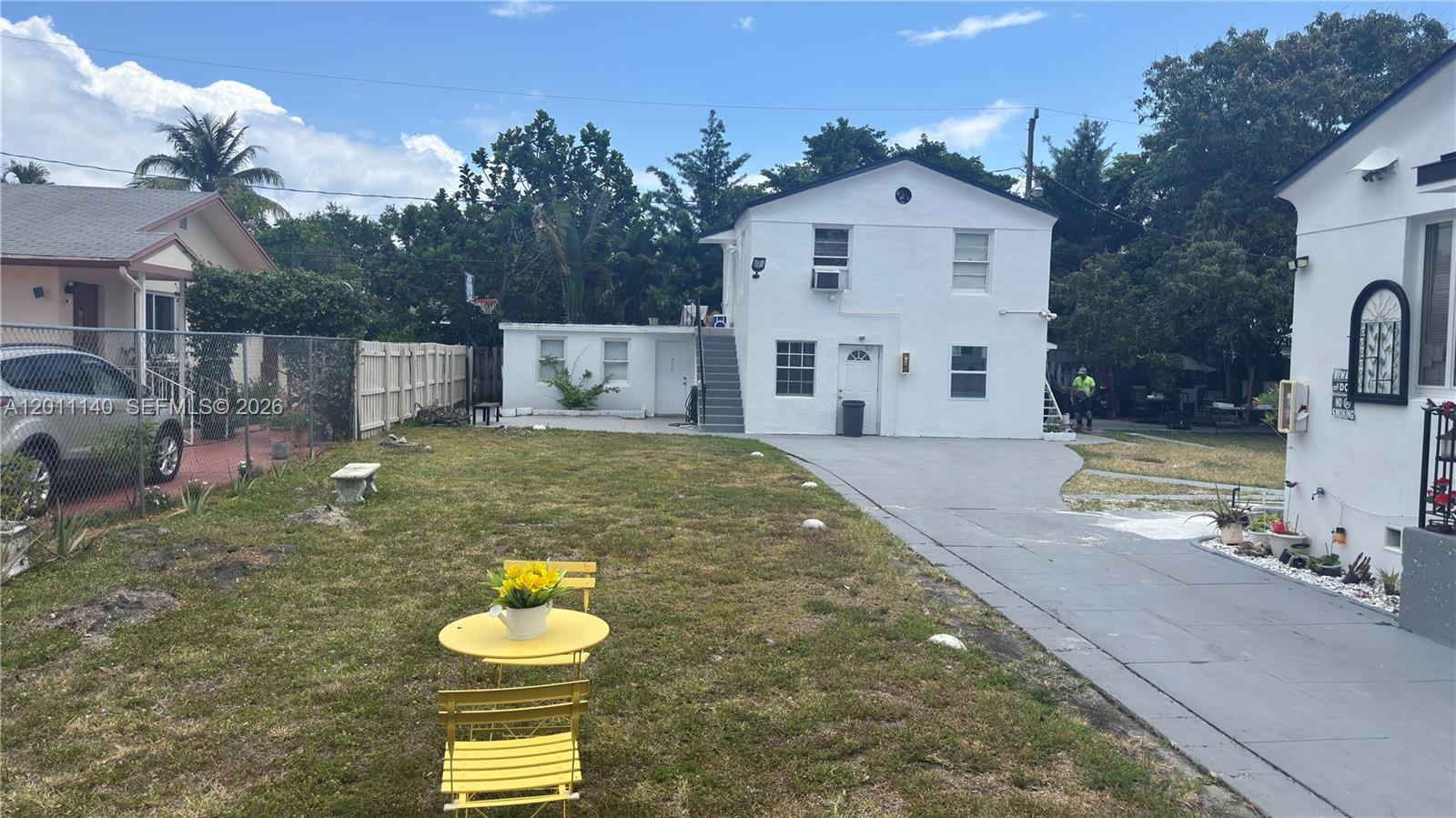 A two-story white house features an exterior staircase and a paved driveway in the backyard — 921 N 17th Ct # 927, Hollywood FL 33020, HOLLYWOOD, FL
