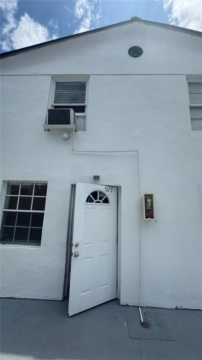 The exterior of a white two-story building features a single door, windows, and an air conditioner — 921 N 17th Ct # 927, Hollywood FL 33020, HOLLYWOOD, FL