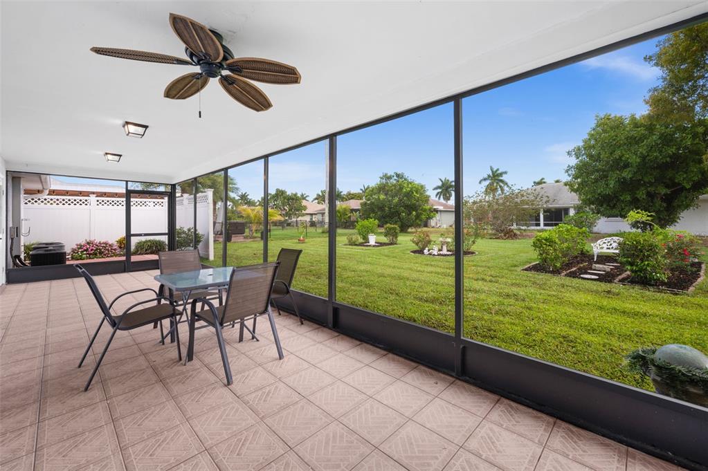 A screened-in patio with tile flooring, a ceiling fan, and a view of a backyard — 706 SW 51ST TERRACE, CAPE CORAL, FL