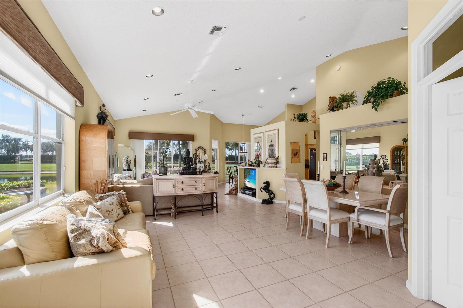 A spacious living and dining area with vaulted ceilings, tile floors, and large windows — 6862 Swansea Lane, Boynton Beach FL 33472, BOYNTON BEACH, FL
