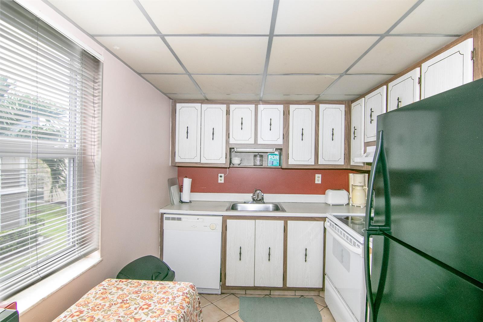 A kitchen with white cabinets, a dark green refrigerator, and a drop ceiling — 39 Burgundy A, Delray Beach FL 33484, DELRAY BEACH, FL