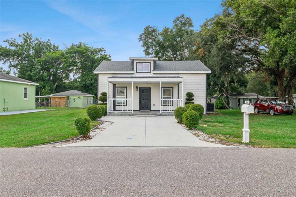 A single-story house with light siding, a front porch, and a concrete driveway — 306 S DISSTON AVENUE, MINNEOLA, FL