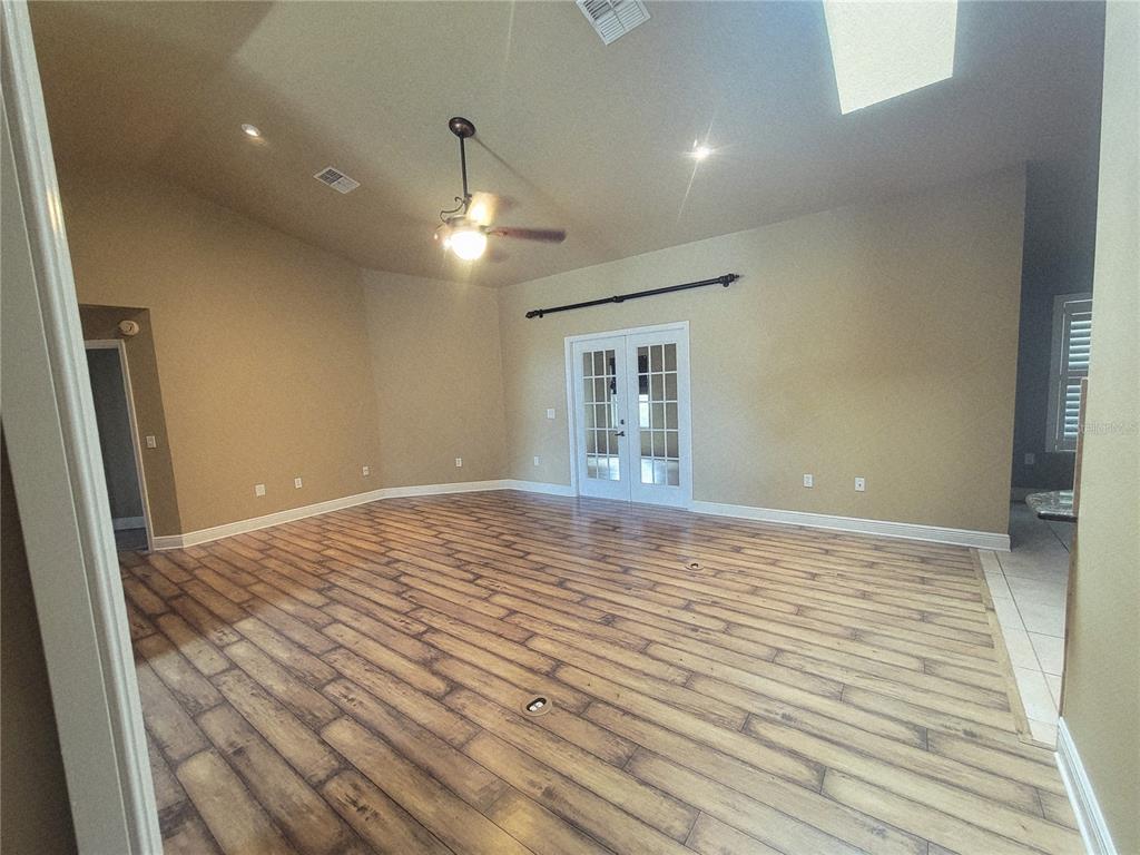 A living room features a large sectional sofa, a wooden coffee table, and wood flooring — 119 BRANDIWOOD COURT, DEBARY, FL