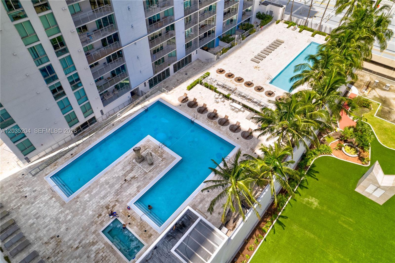 An aerial view shows a multi-level apartment building with two swimming pools and a hot tub — 335 S Biscayne Blvd # 3108, Miami FL 33131, MIAMI, FL