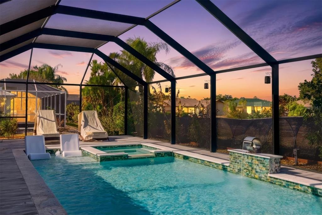 A swimming pool and spa with a water feature are enclosed by a screened lanai — 27052 TIERRA DEL FUEGO CIRCLE, PUNTA GORDA, FL
