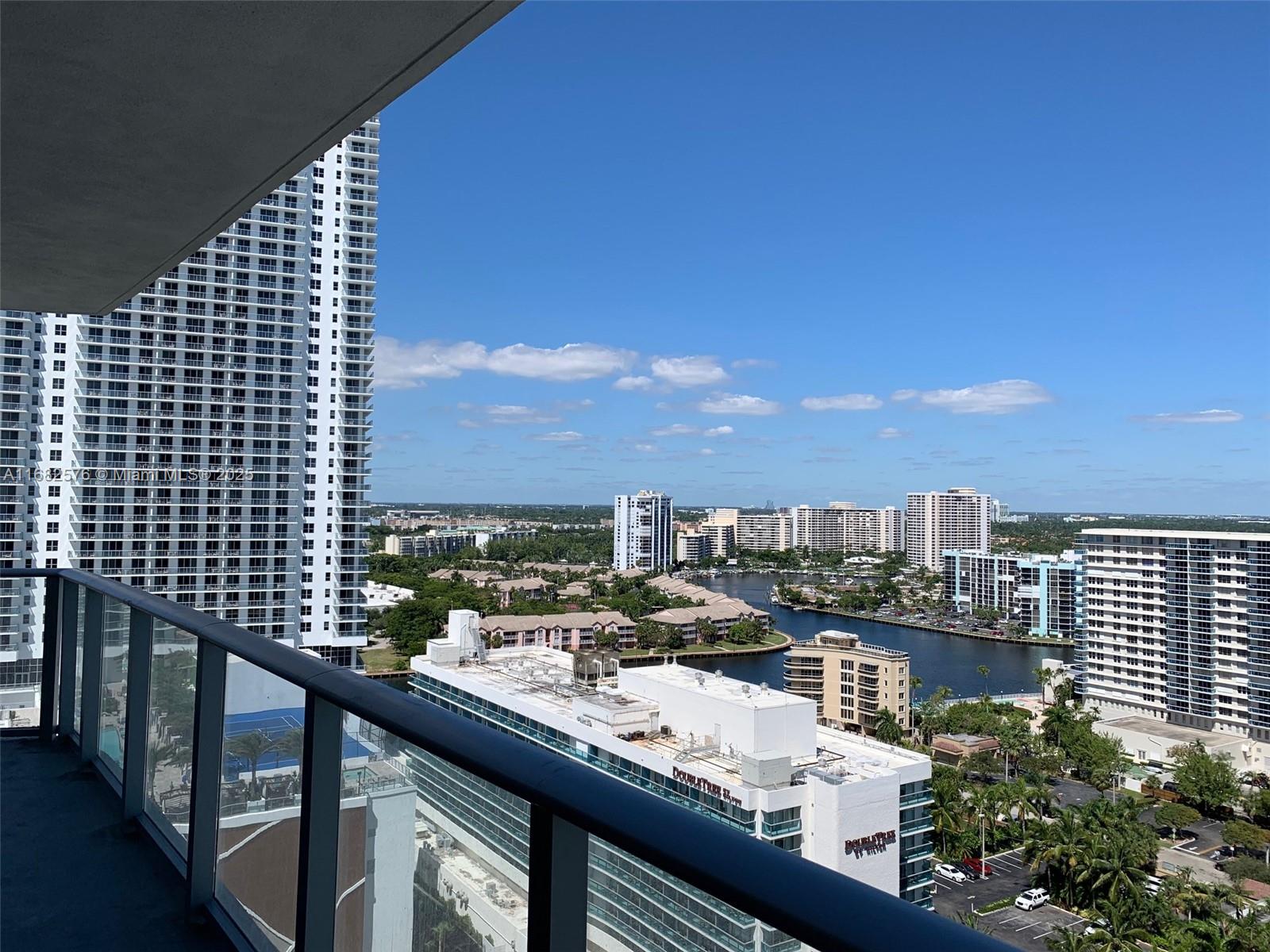 A high-rise balcony overlooks a canal, surrounding residential buildings, and a DoubleTree hotel — 4111 S Ocean Dr # 1512, Hollywood FL 33019, HOLLYWOOD, FL