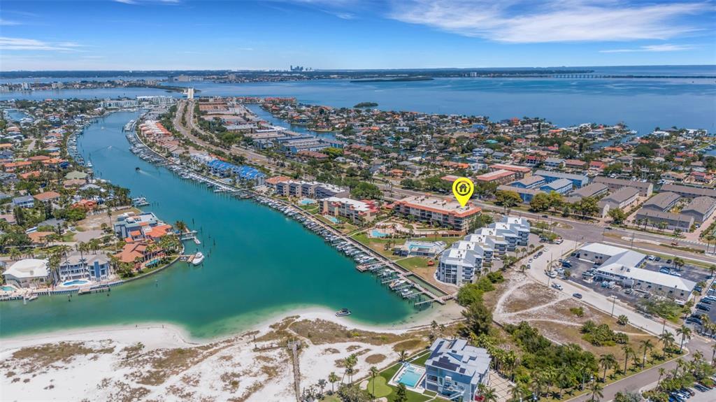 An aerial view shows a coastal residential complex with a marina along a turquoise waterway — 1090 PINELLAS BAYWAY S UNIT A5, ST PETERSBURG, FL