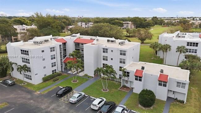 An aerial view shows multi-story apartment buildings with white facades and red roof accents — 9421 Evergreen Pl # 103, Davie FL 33324, DAVIE, FL
