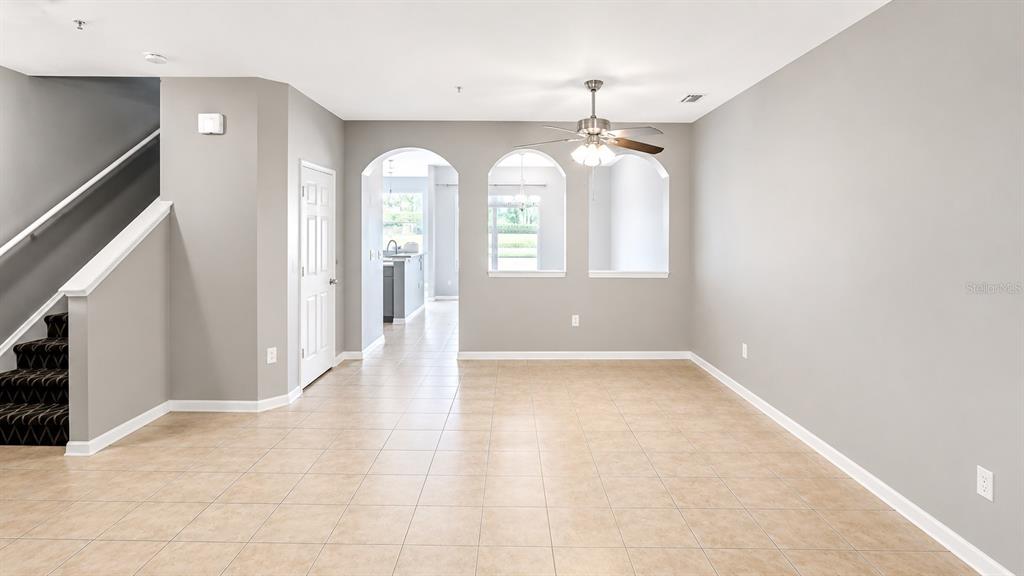 An open living area features tile floors, gray walls, a ceiling fan, and arched cutouts — 3696 PARKRIDGE CIRCLE UNIT 26-105, SARASOTA, FL