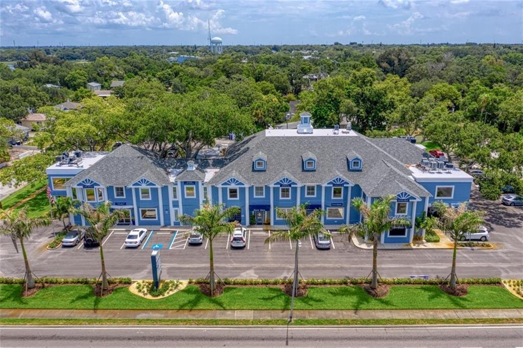 An aerial view of a blue two-story commercial building with a gray shingled roof — 1465 S FORT HARRISON AVENUE, CLEARWATER, FL