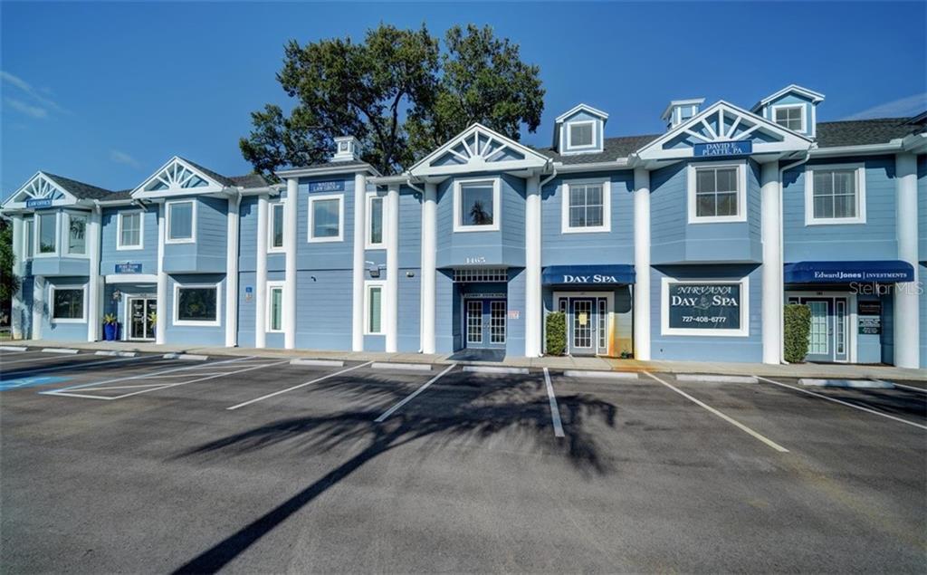 A two-story blue commercial building with multiple storefronts and a paved parking lot in front — 1465 S FORT HARRISON AVENUE, CLEARWATER, FL