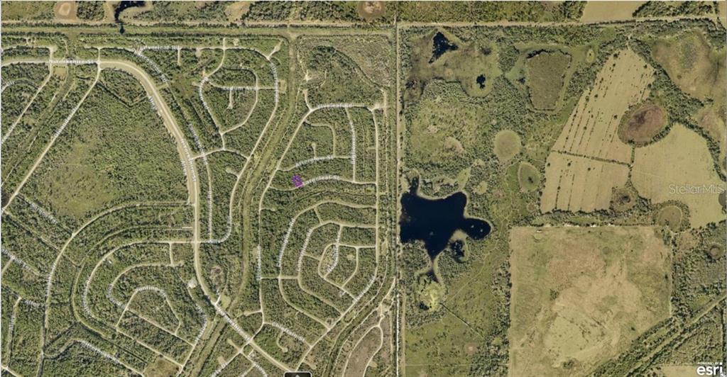 This is an aerial map showing a residential neighborhood adjacent to undeveloped land and lakes — 1127226126 LARGELEAF STREET, NORTH PORT, FL