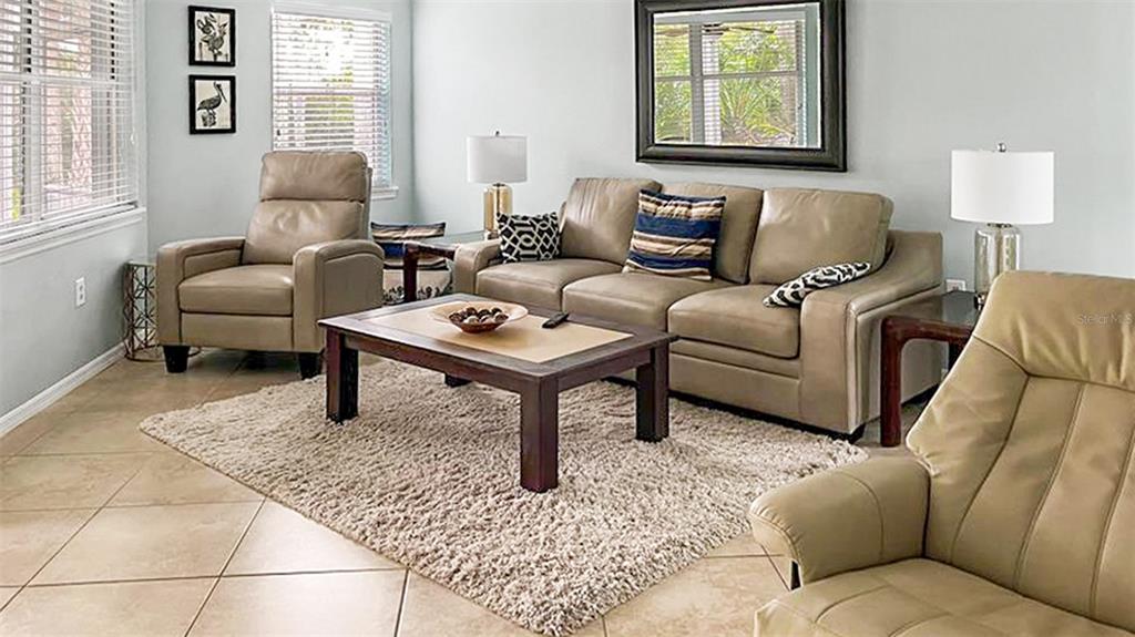 A living room features a beige sofa, two armchairs, a coffee table, and a rug — 1272 SIESTA BAYSIDE DRIVE UNIT 1272-C, SARASOTA, FL