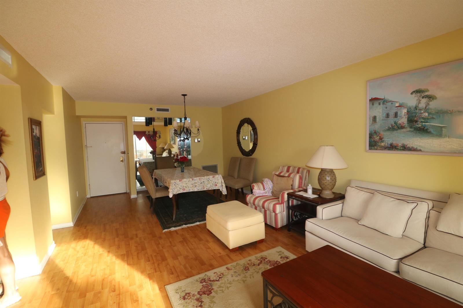 A living and dining area with yellow walls, hardwood floors, and a beige sofa — 4001 Hillcrest Drive # 510, Hollywood FL 33021, HOLLYWOOD, FL