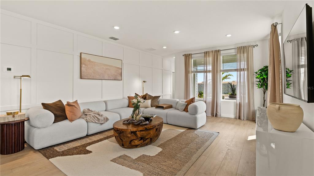 A living room features a white sectional sofa, a wooden coffee table, and paneled walls — 1933 FIELDSTONE STREET, MINNEOLA, FL