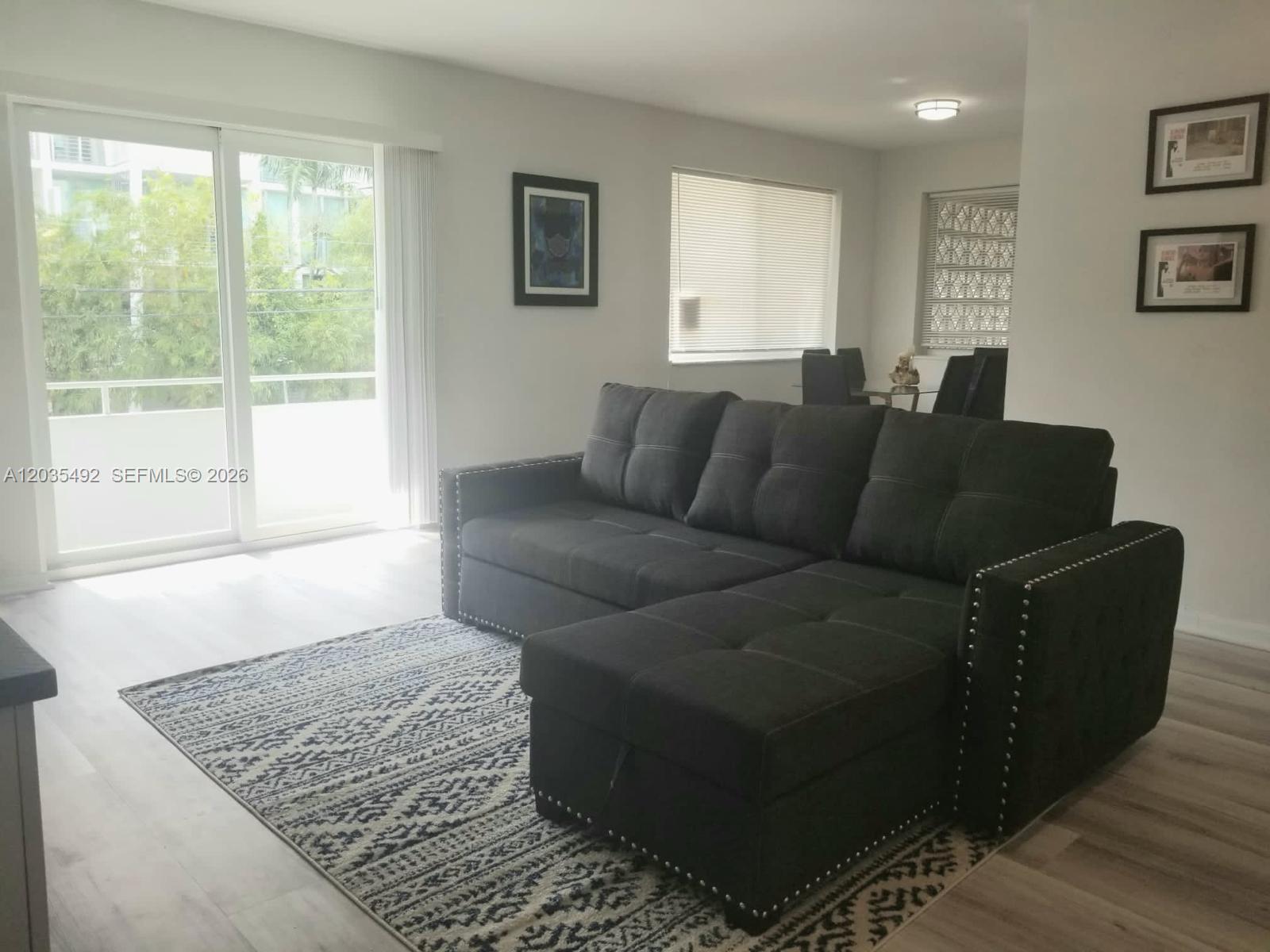 A white kitchen with stainless steel appliances and granite countertops opens into a dining area — 1601 Bay Rd # 7, Miami Beach FL 33139, MIAMI BEACH, FL