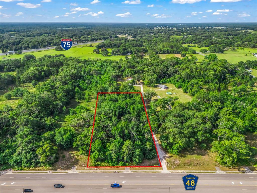 An aerial view shows a rectangular wooded lot bordered by a road and Interstate 75 — 2823 W C 48, BUSHNELL, FL