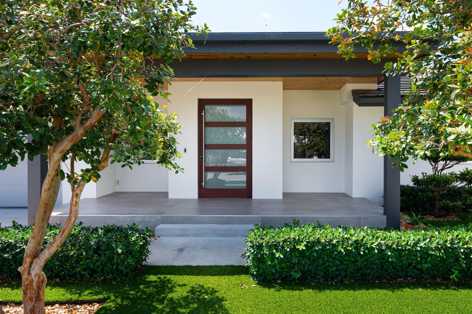 A modern house exterior features a white facade, a dark wood front door, and a porch — 1398 SW 14th Street, Boca Raton FL 33486, BOCA RATON, FL