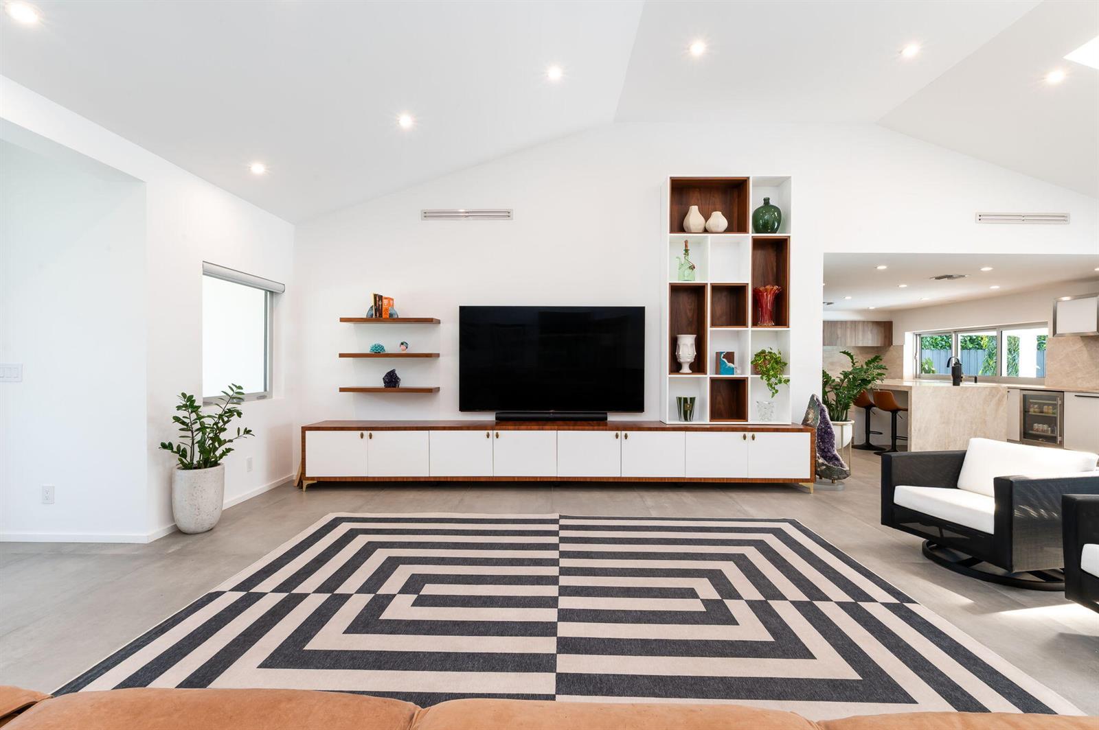 A living room features a large television, built-in shelving, a geometric rug, and white walls — 1398 SW 14th Street, Boca Raton FL 33486, BOCA RATON, FL