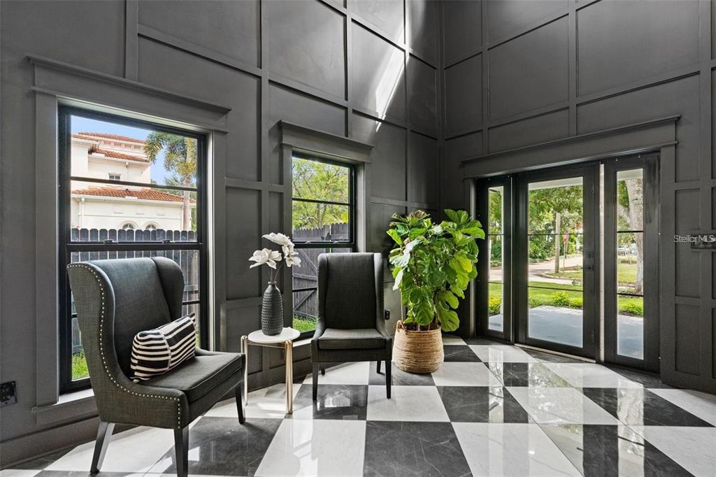 A foyer features dark paneled walls, a black and white checkered floor, and two chairs — 3501 W TACON STREET, TAMPA, FL