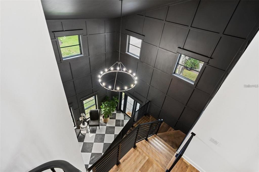 A high-angle view shows a foyer with checkered floors, dark paneled walls, and a chandelier — 3501 W TACON STREET, TAMPA, FL