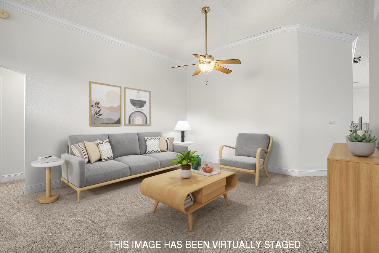 This is a virtually staged living room with a gray sofa, armchair, and coffee table — 966 E 13th Square, Vero Beach FL 32960, VERO BEACH, FL