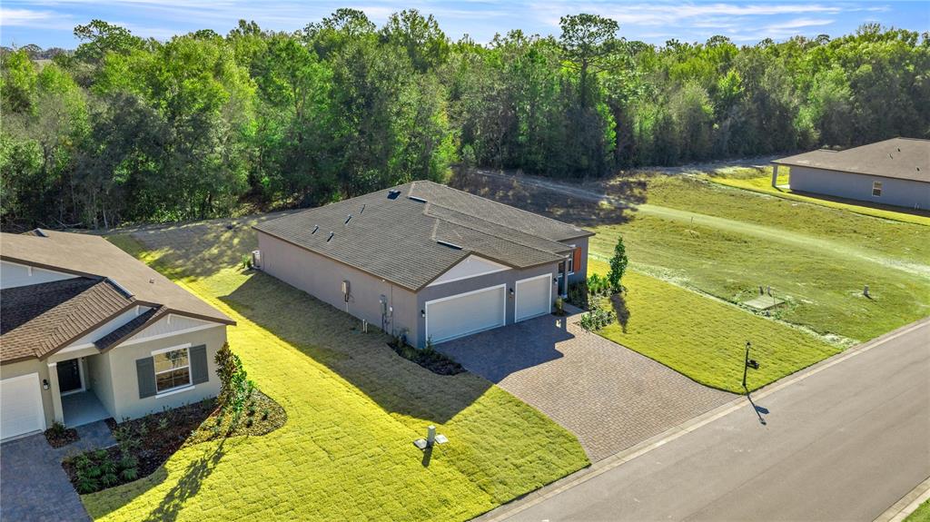 An aerial view of a suburban house with a paved driveway and a grassy yard — 6664 SW 180TH CIRCLE, DUNNELLON, FL