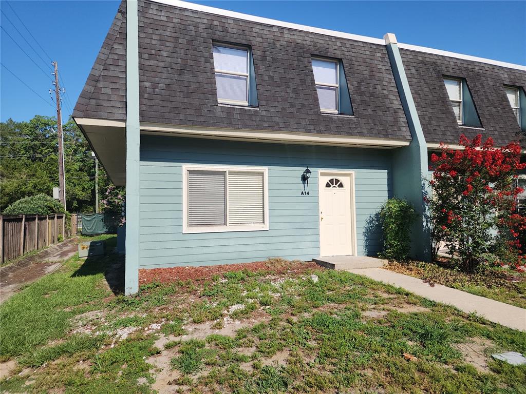 A blue two-story townhouse with a shingled mansard roof and a front entrance — 501 SW 75 STREET UNIT A14, GAINESVILLE, FL