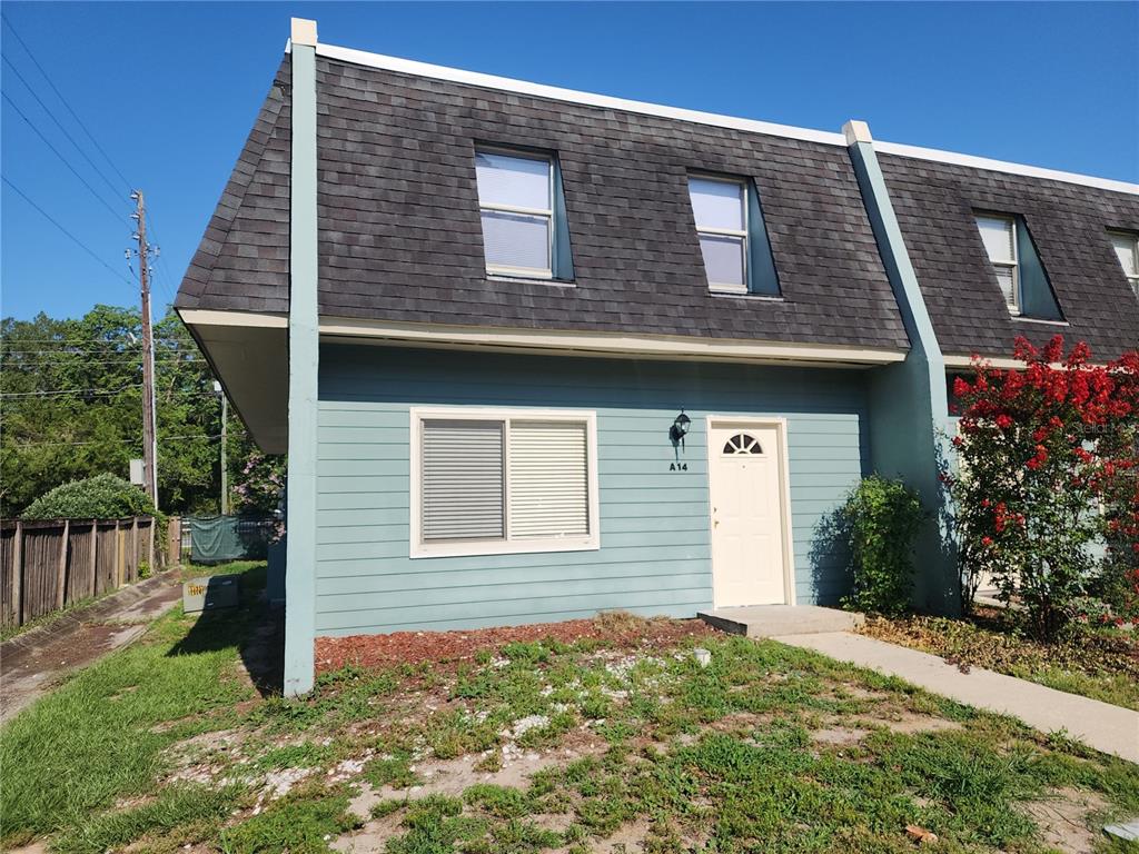 A two-story blue townhouse with a mansard roof and a white front door — 501 SW 75 STREET UNIT A14, GAINESVILLE, FL