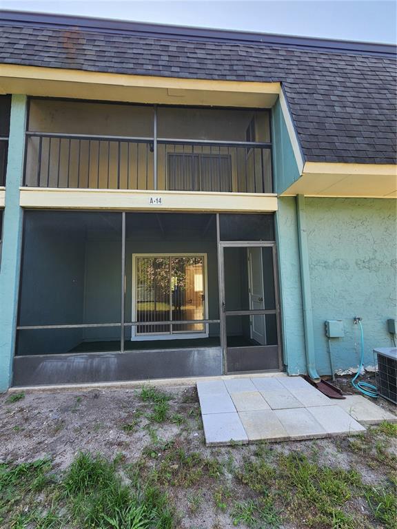 A two-story residential unit features a screened-in ground floor patio and an upper balcony — 501 SW 75 STREET UNIT A14, GAINESVILLE, FL
