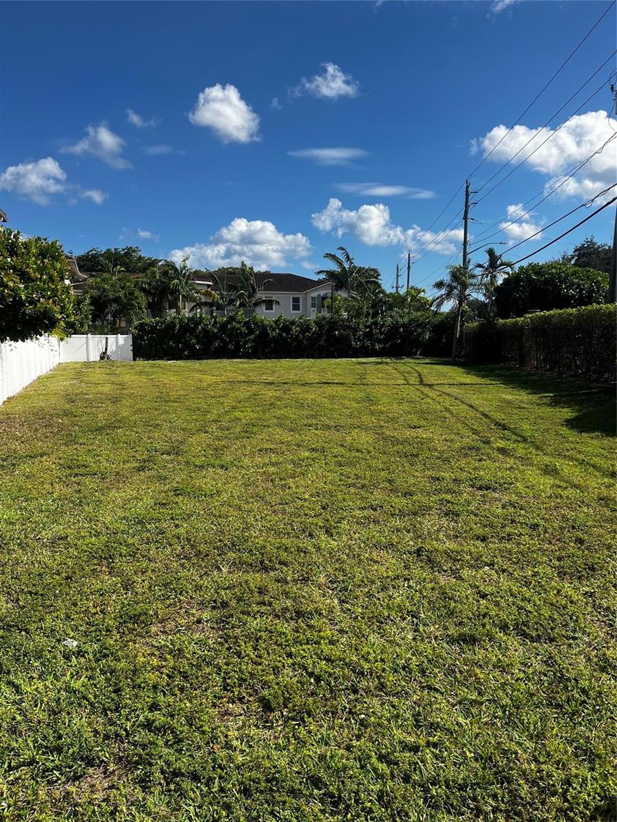A large, flat, grassy residential lot bordered by a white fence and tall hedges — 1855 Copley Place, Delray Beach FL 33445, DELRAY BEACH, FL
