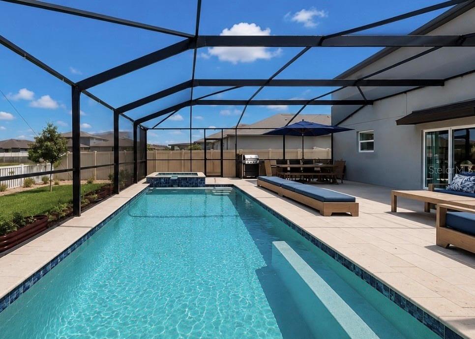 A screened-in patio features a rectangular swimming pool, a hot tub, and outdoor furniture — 5519 BLUE AZURE DRIVE, WIMAUMA, FL