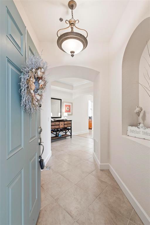 An entryway features a light blue door, tile flooring, an arched wall niche, and a chandelier — 35 OCEAN CREST WAY UNIT 1135, PALM COAST, FL