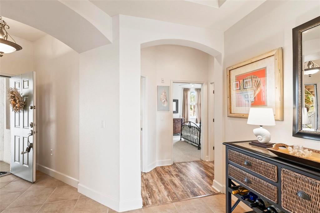 An entryway with tile flooring leads through an arched doorway into a carpeted bedroom — 35 OCEAN CREST WAY UNIT 1135, PALM COAST, FL