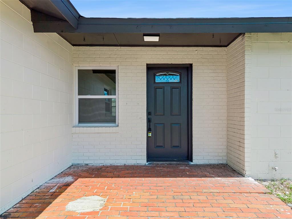A brick patio leads to a dark front door next to a window on a house — 937 BARBADOS AVENUE, ORLANDO, FL