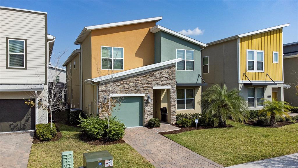 A modern two-story house with a stone facade, a garage, and a paved walkway — 2734 BOOKMARK DRIVE, KISSIMMEE, FL