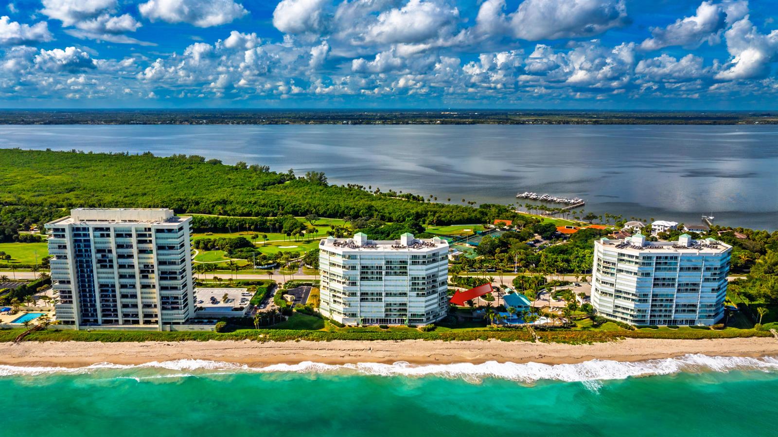 An aerial view of three beachfront condominium buildings along a coastline with a large bay — 8650 S Ocean Drive # 301, Jensen Beach FL 34957, JENSEN BEACH, FL