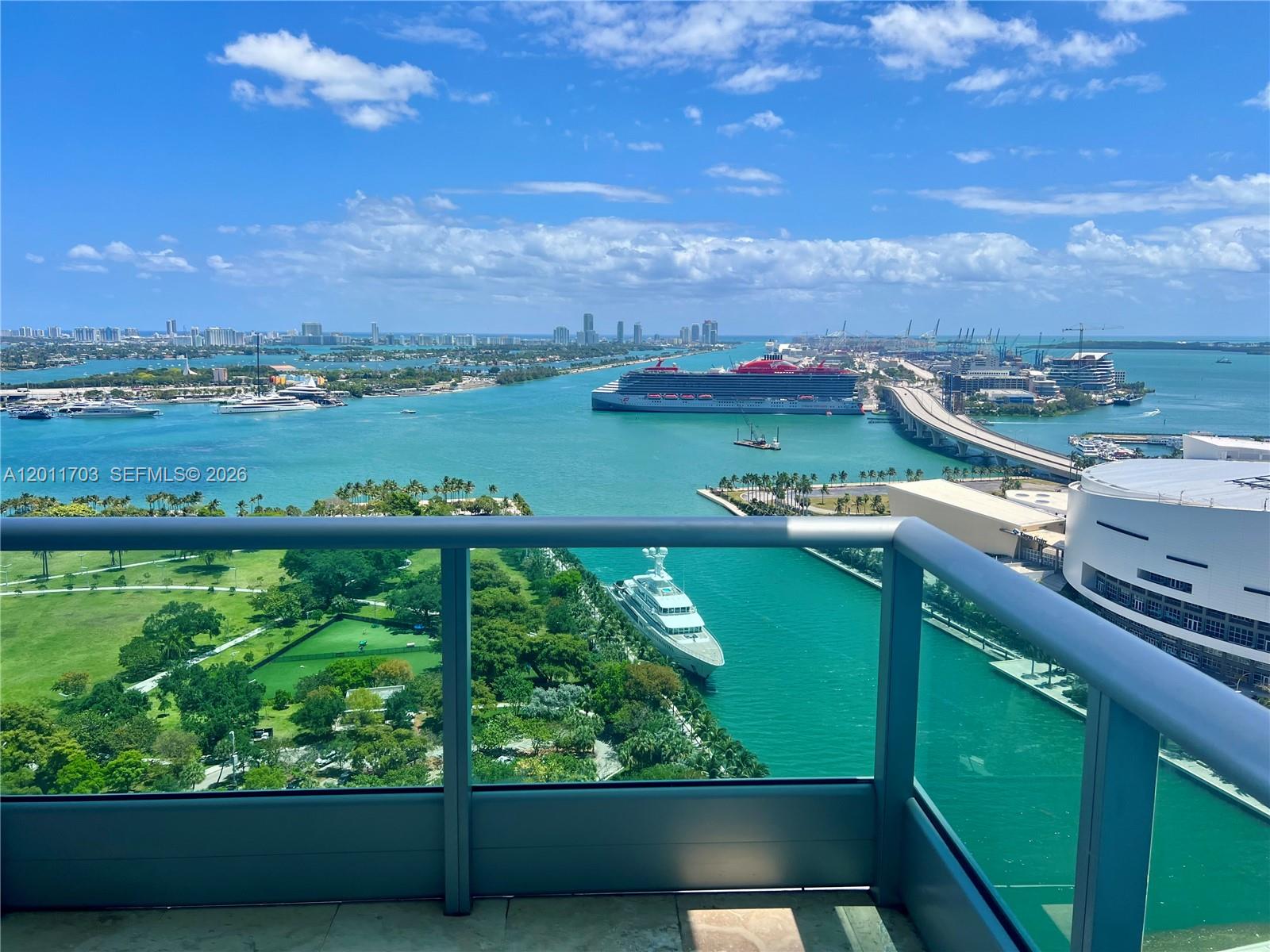 A room with light-colored tile flooring features a large sliding glass door opening to a balcony — 900 Biscayne Blvd # 2904, Miami FL 33132, MIAMI, FL
