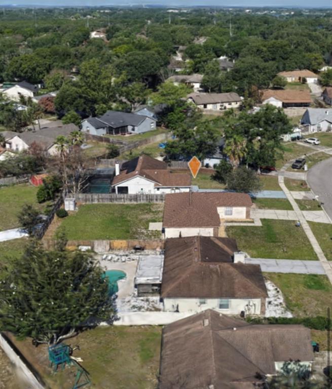 An aerial view shows a suburban neighborhood with several single-family homes and backyard swimming pools — 9132 NEW ORLEANS DRIVE, ORLANDO, FL
