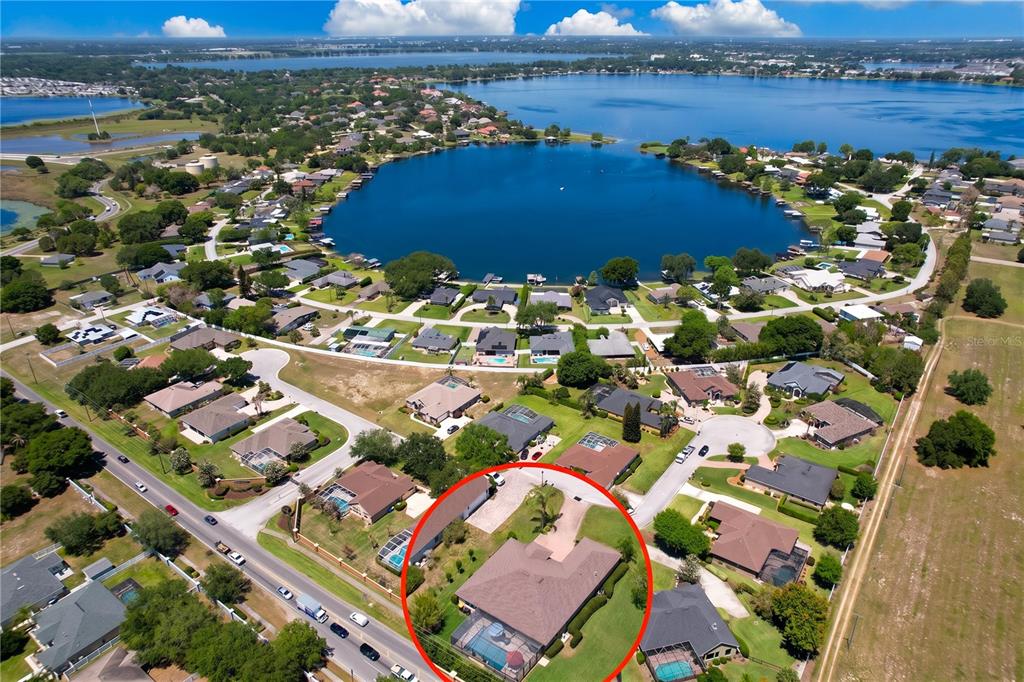 A single-story house with a beige exterior, a brick driveway, and an American flag — 408 TALAMONE DRIVE, WINTER HAVEN, FL