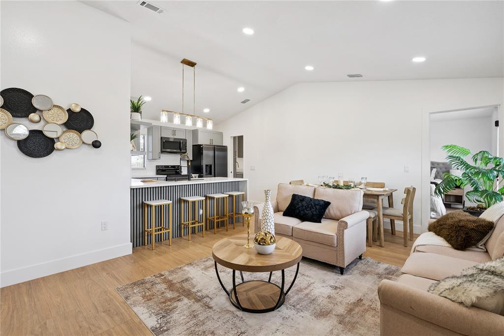 An open-concept living and dining area features a kitchen island with bar seating — 65 S COURTLAND BOULEVARD, DELTONA, FL